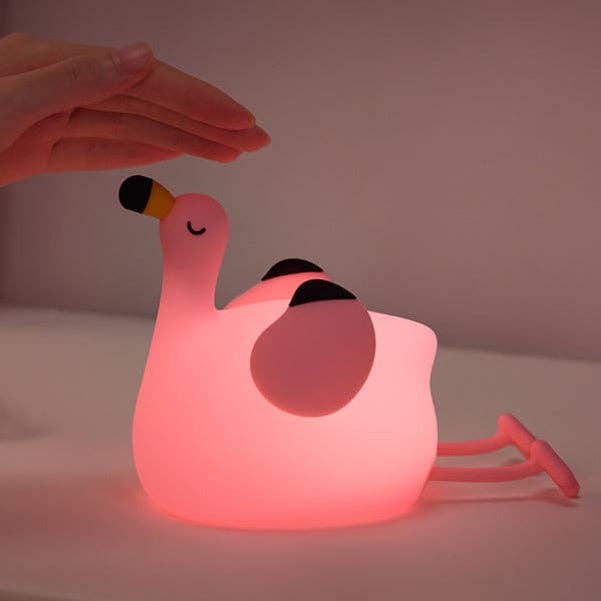 Veilleuse LED flamant rose en silicone allumée avec lumière rose dans une chambre d'enfant